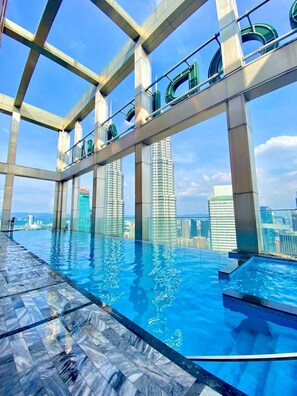 Ein Rooftop-Infinity-Pool mit freiem Blick auf die Skyline der Stadt.