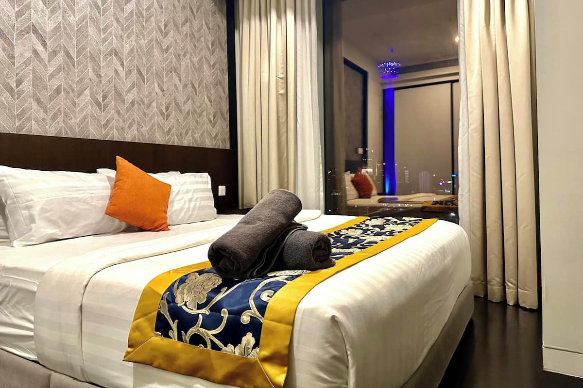 Ein Hotelzimmer mit Bett, Blick auf die Stadt durch ein Fenster und modernem Interieur.