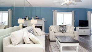 A modern living room with two sofas, a coffee table, a fireplace, and a TV. - Beautiful 3 Bd condo on 23rd Street with outdoor pool. (Ocean City)