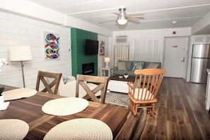 A dining area with a wooden table, chairs, and a television.