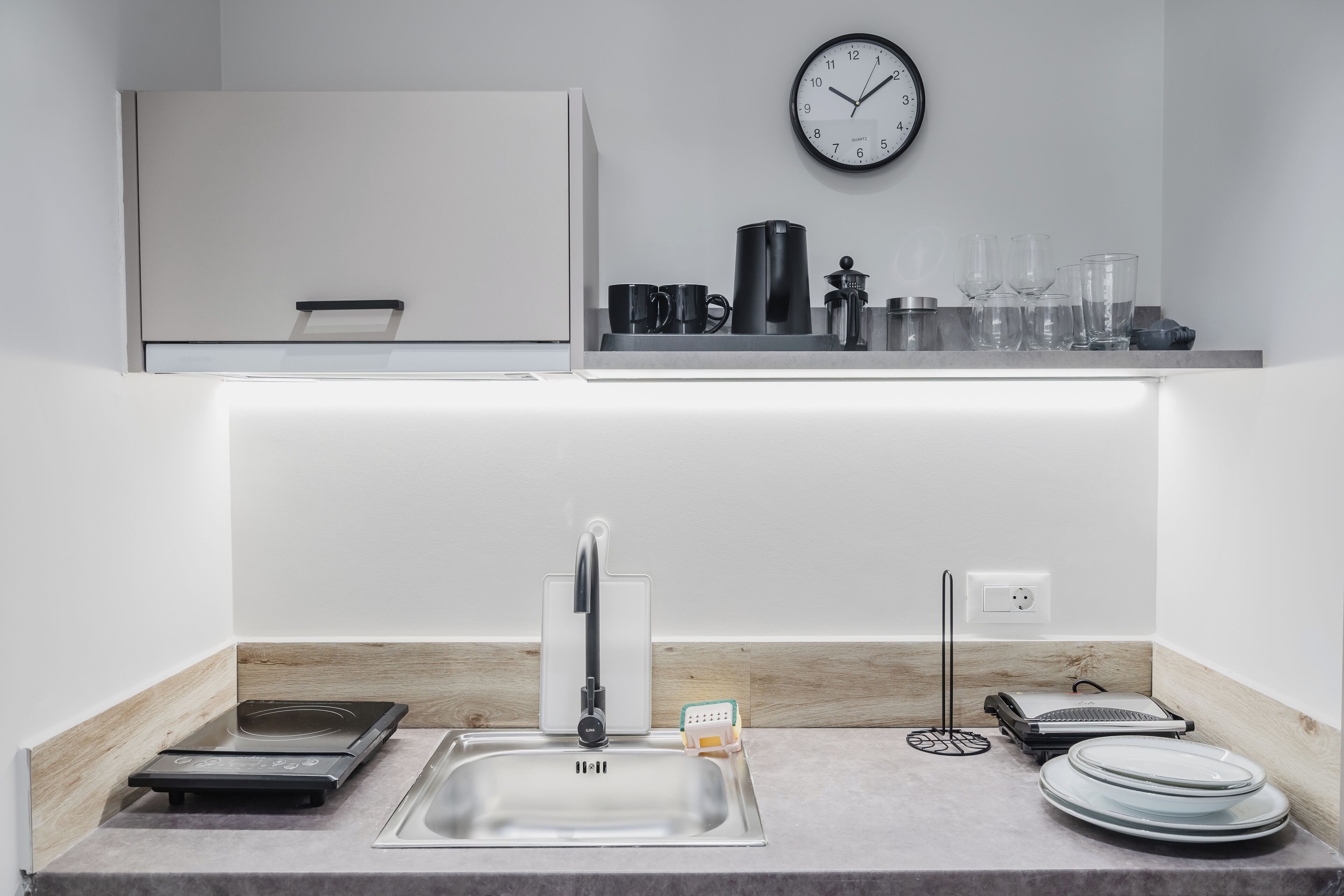 A modern kitchen with a built-in stove, a sink, and a countertop.