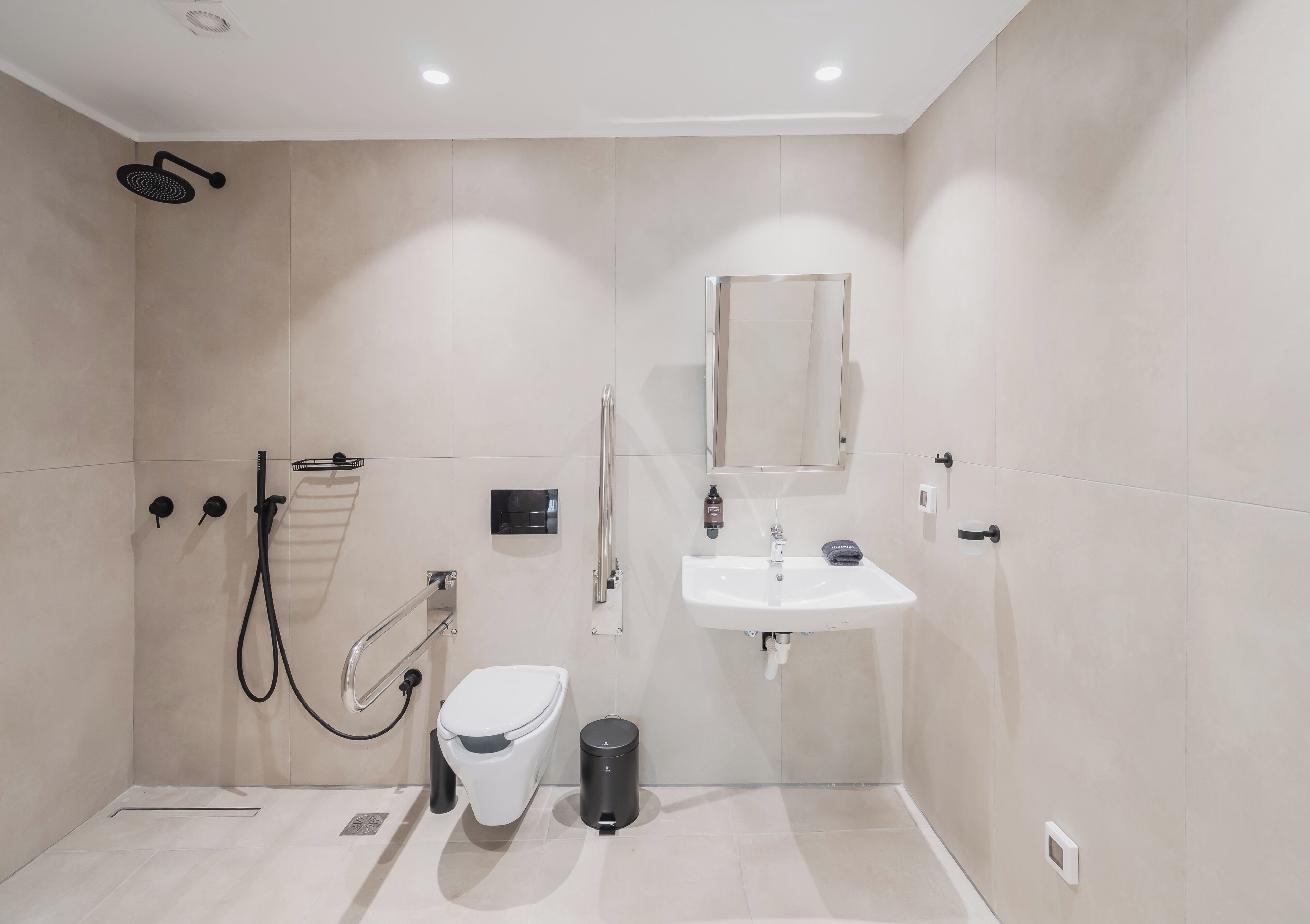 A modern bathroom with a shower, toilet, and sink.
