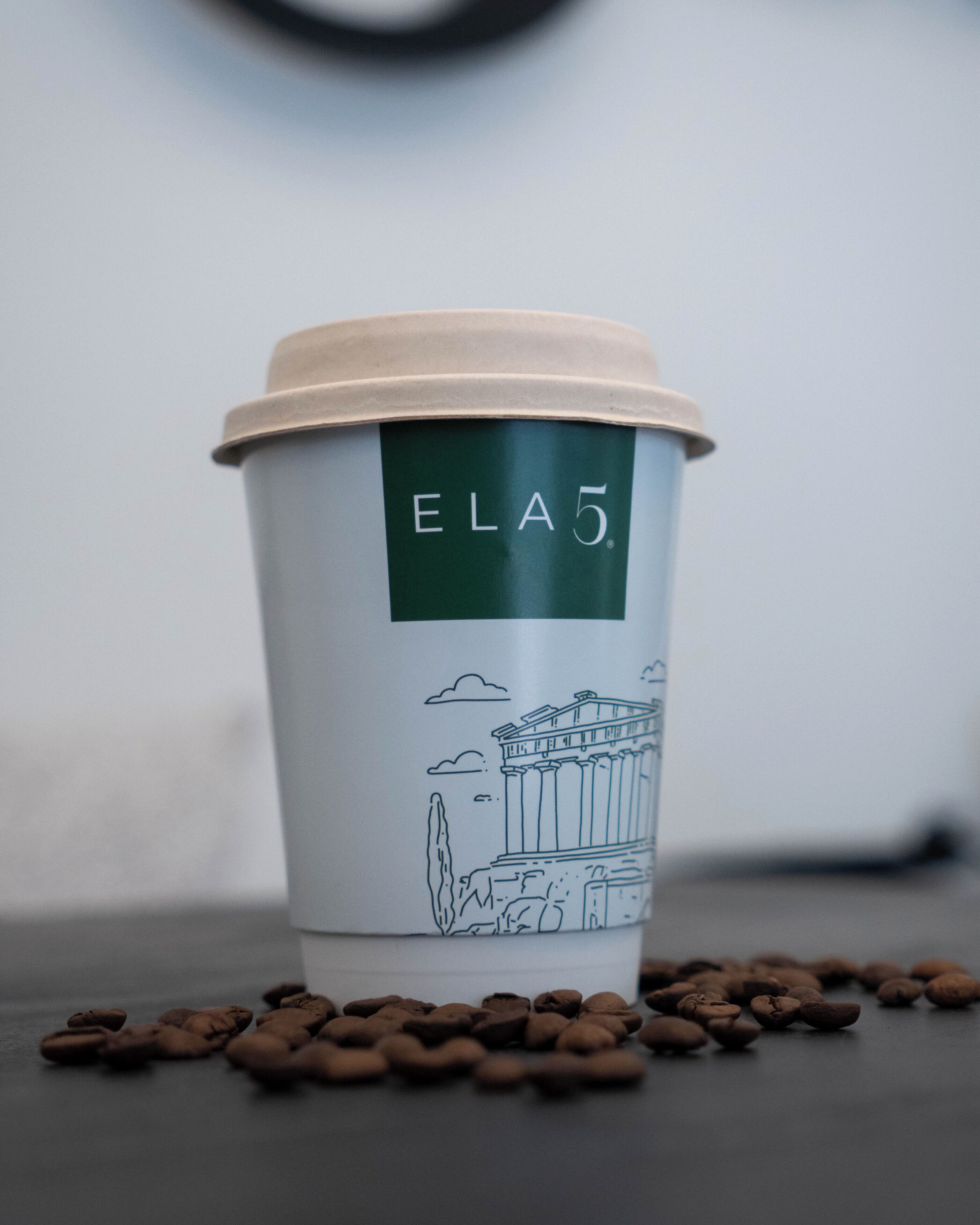A coffee cup with a lid and a green label that reads "ELA5".