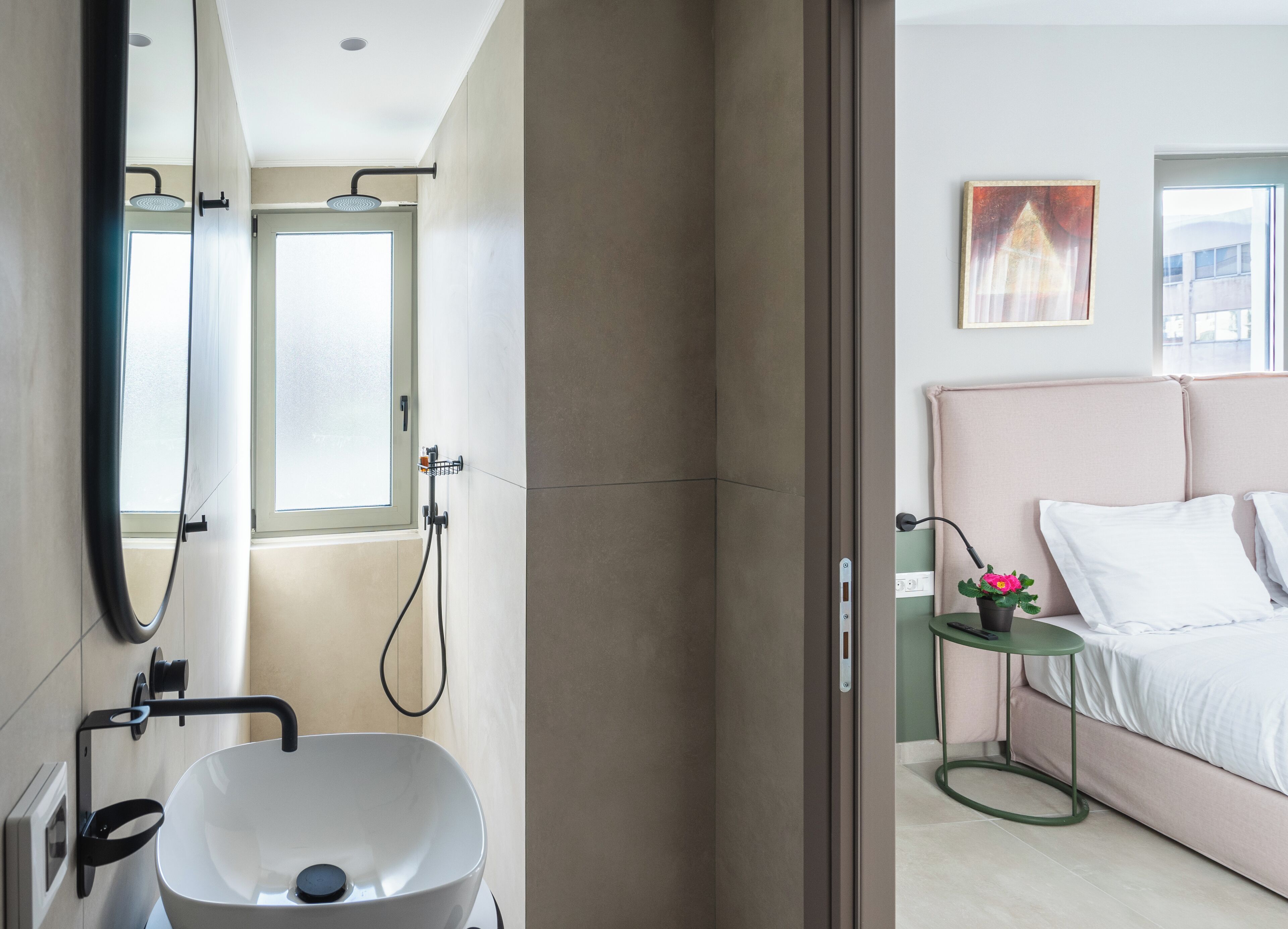 A modern bathroom with a large mirror, a white sink, and a shower.