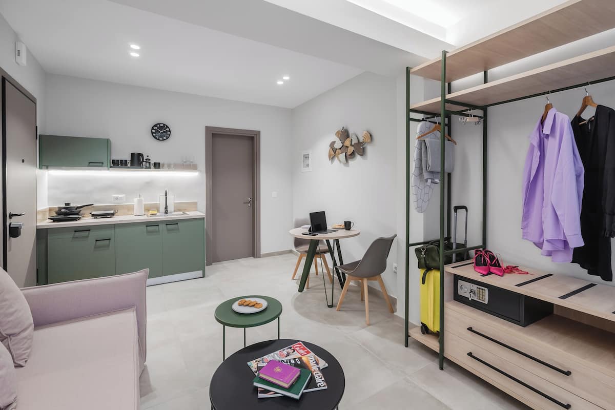 A modern, compact living space with a kitchenette, dining area, and a built-in wardrobe.