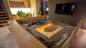 A modern living room with a sofa, coffee table, and a wooden bench.