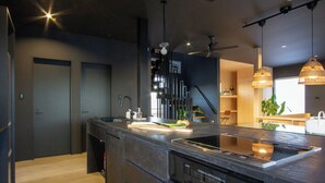 A modern kitchen with a large island, built-in appliances, and pendant lighting.