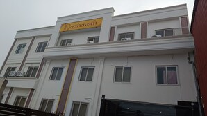 A multi-story building with a prominent yellow sign reading "Raghavam" above the entrance. - RAGHAVAM (Faizabad)