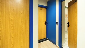 A hallway with wooden doors, one marked with the number 102, and blue trim. - Delightful Hygiene Jacuzzi Junction Massager 5Min toCAairport studio in Cairo (Cairo Governorate)