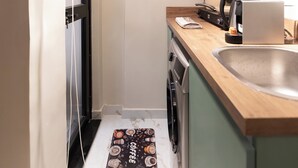 A compact kitchen with a washing machine, a coffee maker, and a wooden countertop. - Delightful Hygiene Jacuzzi Junction Massager 5Min toCAairport studio in Cairo (Cairo Governorate)