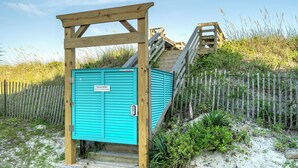 Une structure en bois avec une porte turquoise, une rampe en bois et un escalier en bois menant à l’étage.