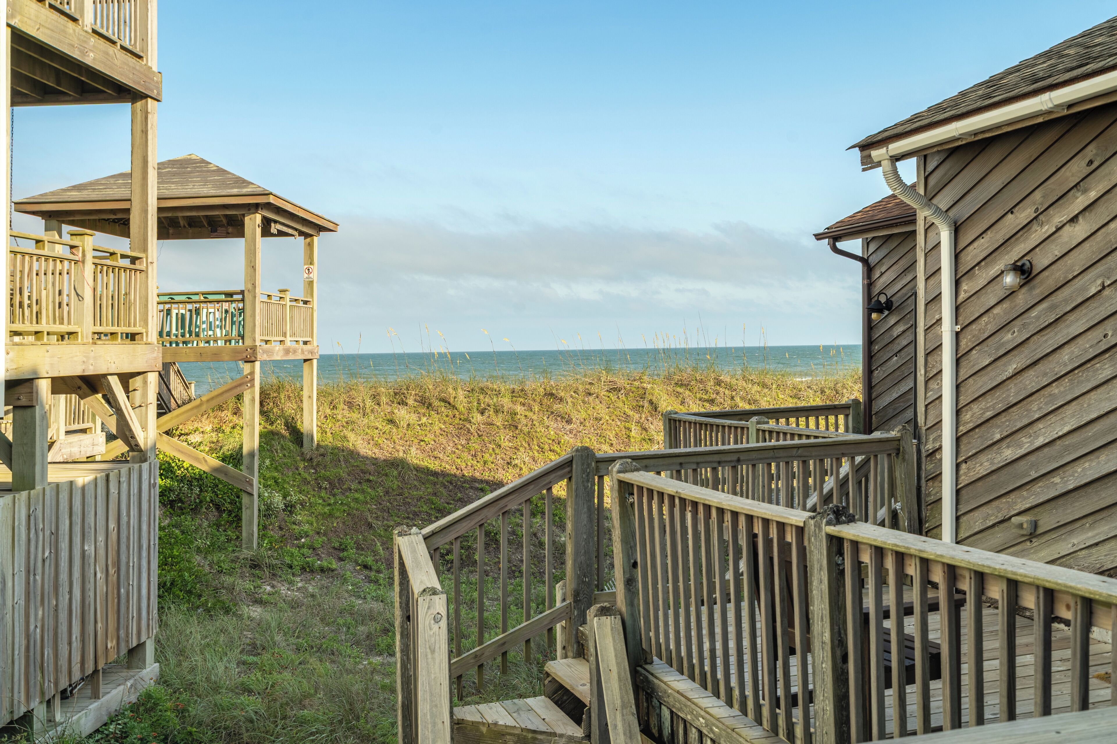 A wooden structure with a viewing platform and a staircase leading to a beach.