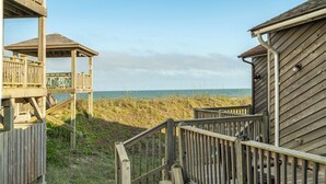 Une structure en bois dotée d’une plateforme d’observation et d’un escalier menant à une plage.