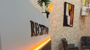 A reception area with a marble-patterned floor and a reception desk with a sign that reads "RECEPTION".