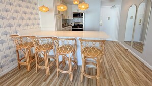 Una cocina moderna con una isla central, taburetes de bar e iluminación colgante.