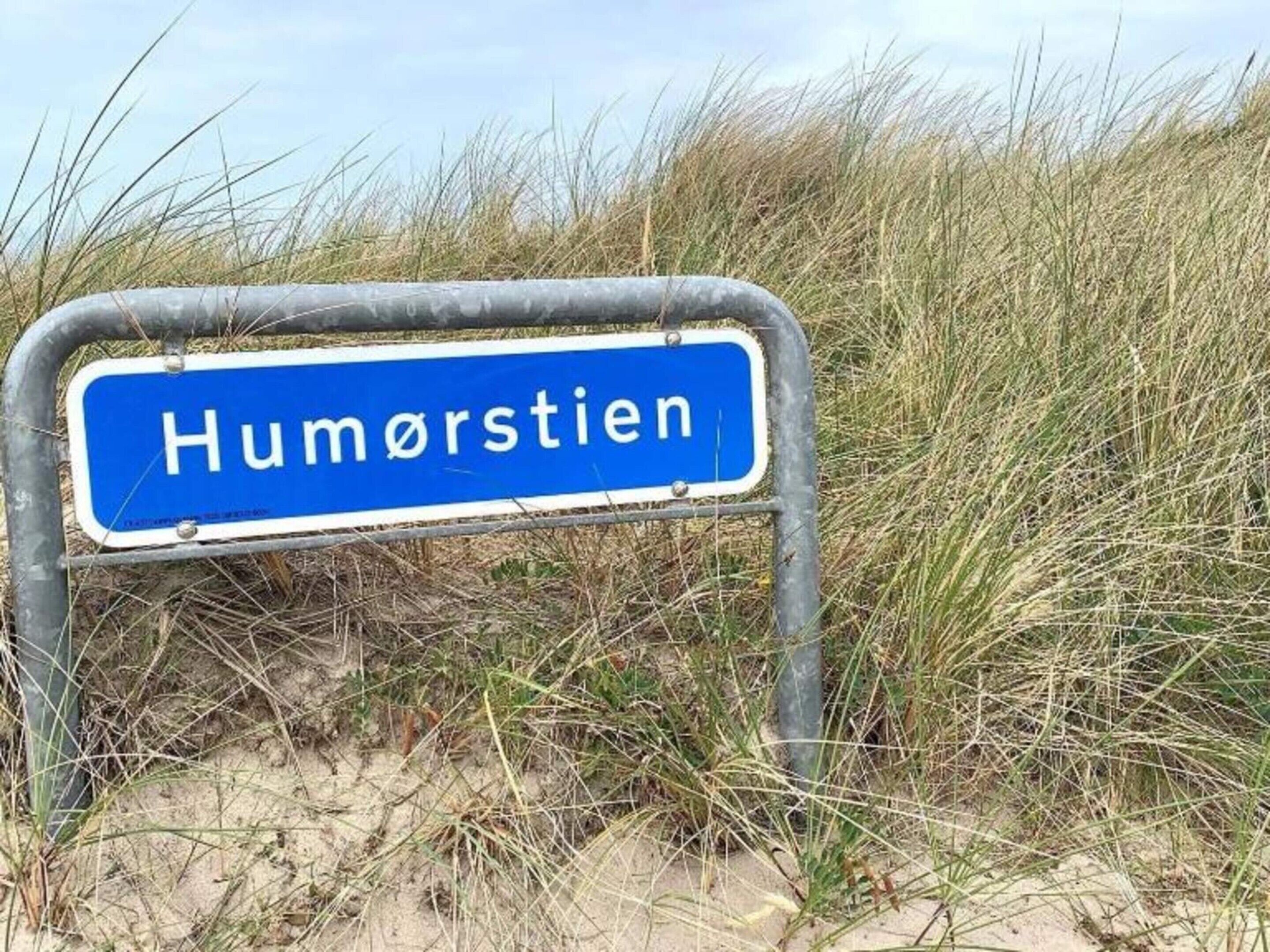 Un panneau indiquant « Humørstien » dans un cadre rural.
