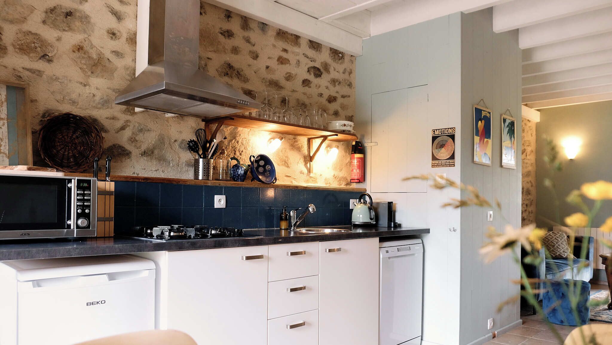 Una cocina moderna con protector mural de piedra, microondas, estufa y lavavajillas.