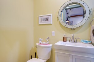 A bathroom with a toilet, sink, and mirror.