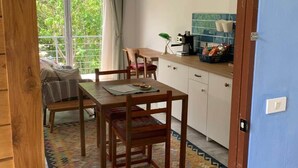 Un rincón comedor acogedor con una mesa y sillas de madera, un tapete estampado y vistas al verdor exterior.