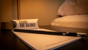 A notebook with a pencil and a note that says "ENJOY THE SILENCE" on a bedside table in a hotel room. - w Elegant 1BR Retreat in the Heart of San Isidro (Lima)