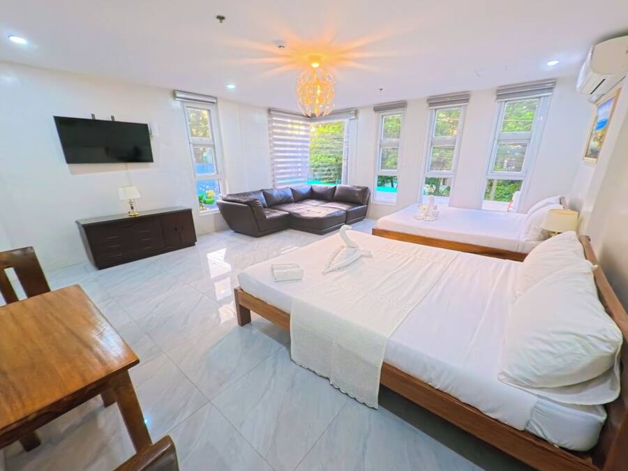 Un dormitorio con cama, escritorio, sofá y televisor.