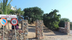 A stone wall with a no parking sign and a speed limit sign.