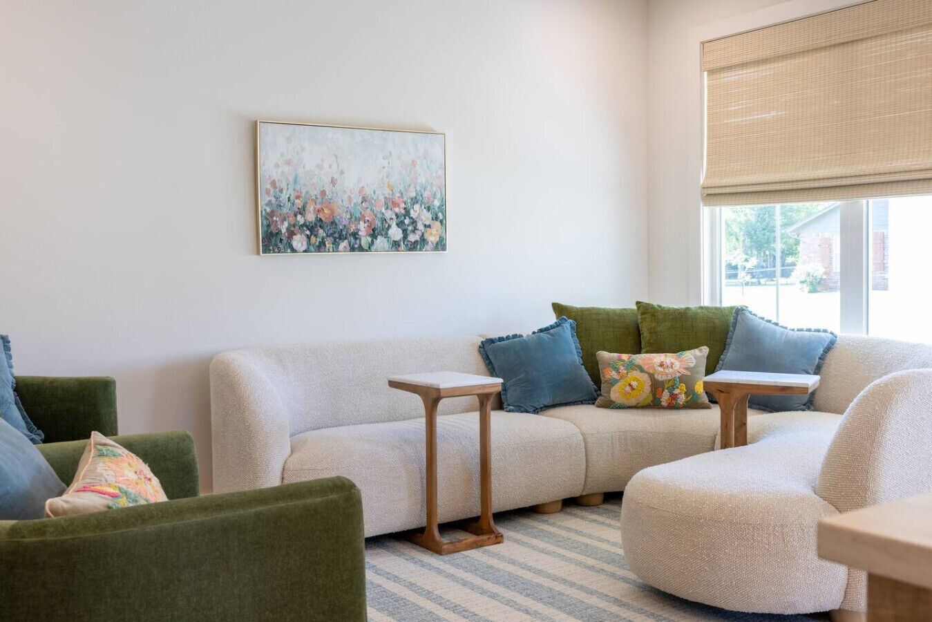 Ein Wohnzimmer mit einer Couch, Sesseln, einem Couchtisch und einem Bild an der Wand.