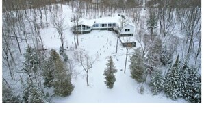 A large, modern house surrounded by a snowy landscape.