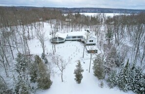 Una casa grande y moderna rodeada por un paisaje nevado.