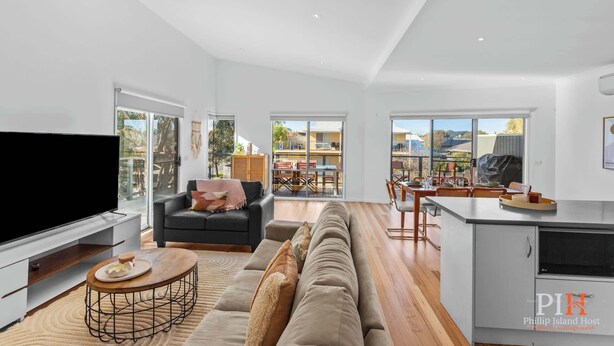 A spacious living room with a large TV, a sofa, and a dining area with a kitchen. - Chloe Retreat in Cowes (Cowes)