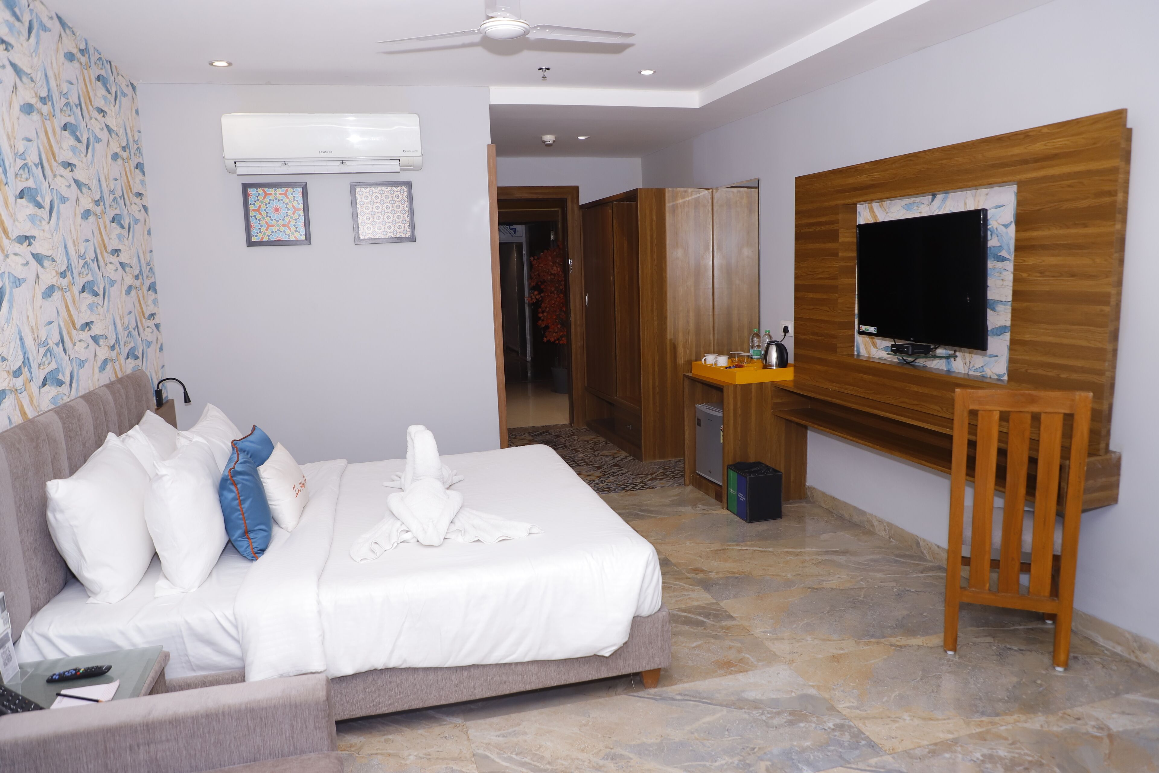 Ein Hotelzimmer mit Bett, Schreibtisch, Fernseher und Kleiderschrank.