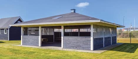 A single-story house with a covered patio area, a visible garage, and a well-maintained lawn.