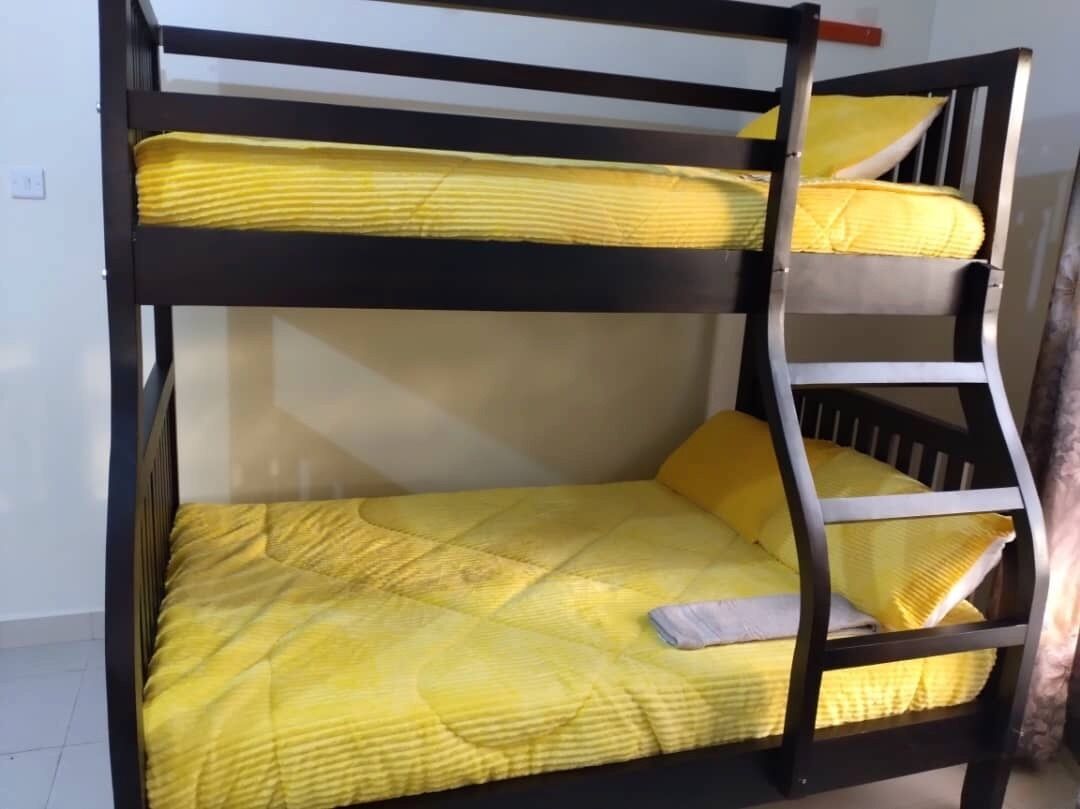 Un lit superposé avec une literie jaune et une échelle.
