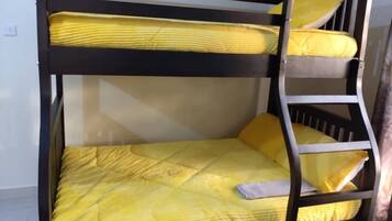 Un lit superposé avec une literie jaune et une échelle.