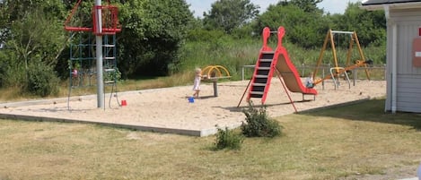 A playground with a slide, swings, and climbing structures.