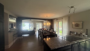 Una cocina amplia con una isla central, un comedor con sillas y vistas al exterior.