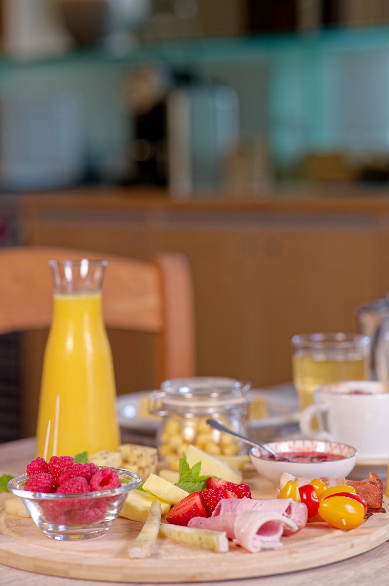 En frukostbuffé med olika sorters mat och dryck upplagd på en träbricka.
