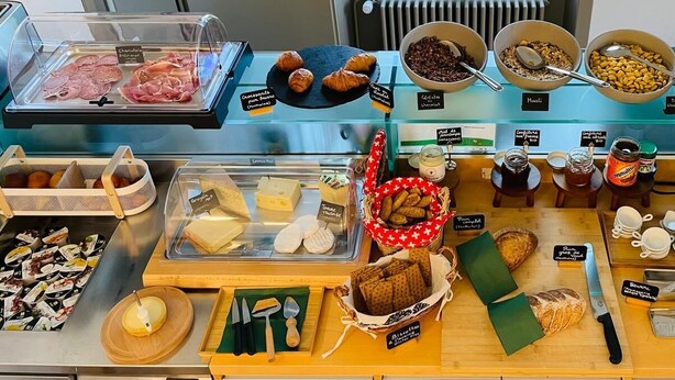 Une vitrine de boulangerie présentant diverses pâtisseries, du pain et des accompagnements.