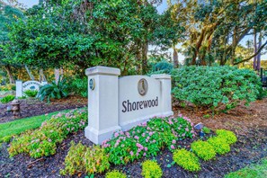 A sign for Shorewood with a number 21 plaque, surrounded by landscaped gardens with various shrubs and flowers.
