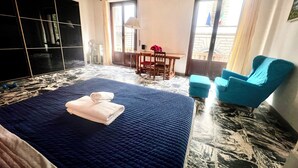 A hotel room with a large bed, a desk, a chair, and a balcony with a view. - Cozy Sweet Marbel room in the center of Florence (Firenze)