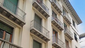 A multi-story building with stone facade, balconies, and a ground entrance. - Cozy Sweet Marbel room in the center of Florence (Firenze)
