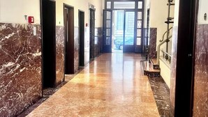 A marble-floored hallway with doors on both sides, leading to an open area with a view. - Cozy Sweet Marbel room in the center of Florence (Firenze)