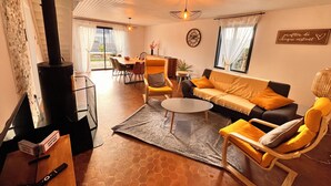 Een gezellige woonkamer met een open haard, een eethoek en een bank.
