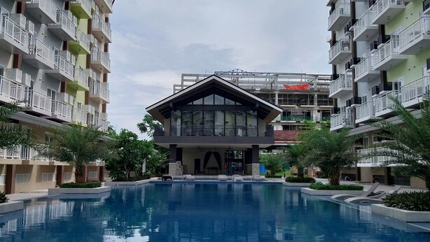 Une piscine entourée d’immeubles résidentiels à plusieurs étages, dotés de balcons.