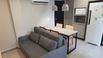 Cozinha moderna com área de refeições, incluindo sofá e cadeiras.