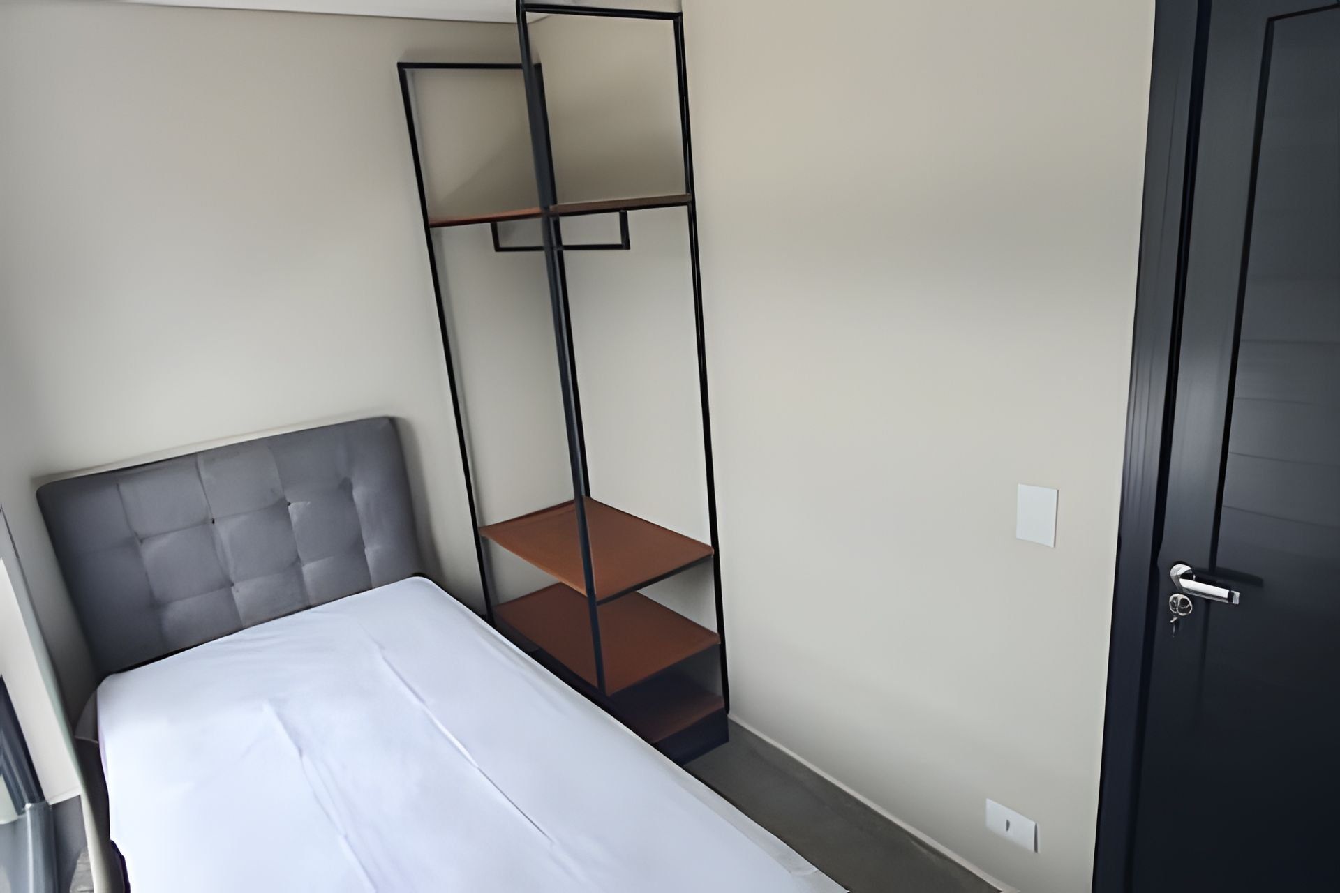 Un dormitorio con cama, armario empotrado y una puerta.
