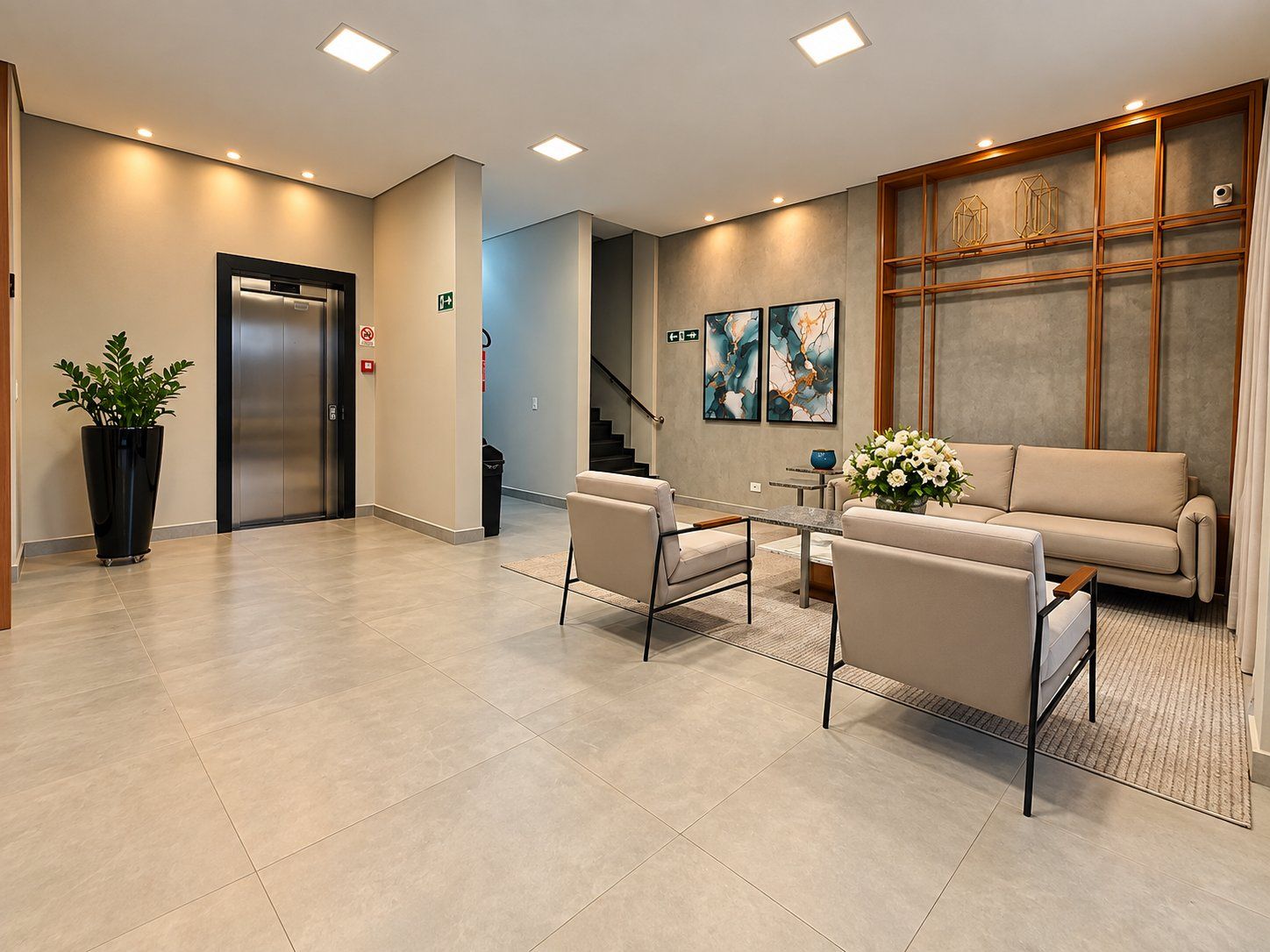 A modern lobby with a reception desk, seating area, and an elevator.
