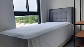 Ein Schlafzimmer mit Bett, Fenster und einer eingebauten Ablagefläche.