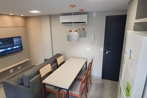 Una cuina moderna amb zona de menjador, aire condicionat integrat i televisió de pantalla plana.