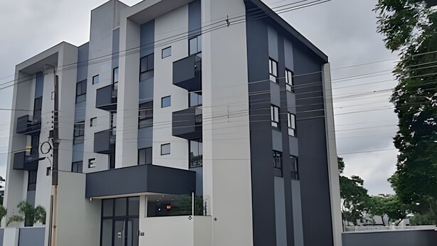 Un edificio a più piani con un design architettonico moderno, caratterizzato da balconi e ampie finestre.